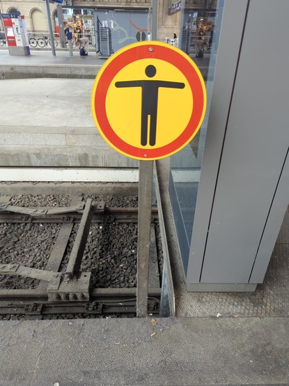am Zugang zum Kopfgleis ist ein gelbes Schild mit rotem Rand und schwarzem männecken quer zum Gleis angebracht.
dahinter geht es den gesamten Bahnsteig entlang 70cm in die Tiefe.