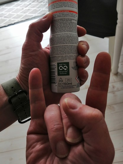 Holding a deodorant can with a label printed on it reading 