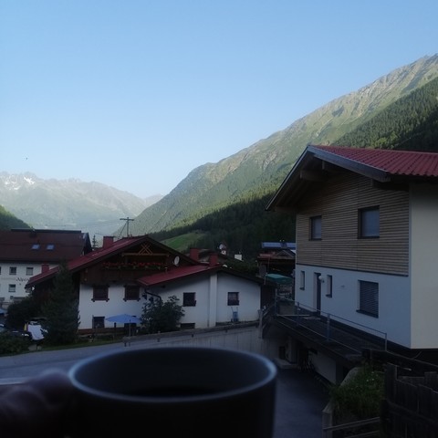Blick auf die Berge hinterm Dorf , Kaffeetasse unten im Bild 